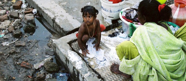 Kleines Mädchen beim Wäschewaschen in einem indischen Slum. Foto: Petra Welzel